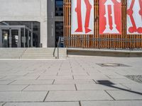 a group of people riding skateboards near wooden panels and stairss with artwork on them