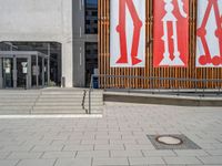 a group of people riding skateboards near wooden panels and stairss with artwork on them