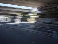 a motion blurry shot of a street with buildings and a bridge in the background