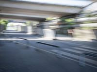 a motion blurry shot of a street with buildings and a bridge in the background