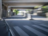 a motion blurry shot of a street with buildings and a bridge in the background