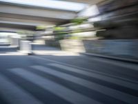 a motion blurry shot of a street with buildings and a bridge in the background