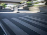 a motion blurry shot of a street with buildings and a bridge in the background