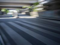 a motion blurry shot of a street with buildings and a bridge in the background
