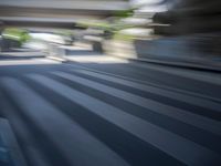 a motion blurry shot of a street with buildings and a bridge in the background