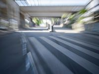 a motion blurry shot of a street with buildings and a bridge in the background