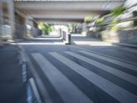 a motion blurry shot of a street with buildings and a bridge in the background