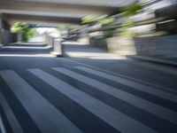 a motion blurry shot of a street with buildings and a bridge in the background
