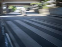 a motion blurry shot of a street with buildings and a bridge in the background