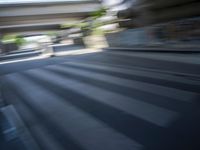 a motion blurry shot of a street with buildings and a bridge in the background