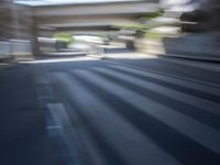 a motion blurry shot of a street with buildings and a bridge in the background