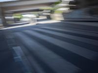 a motion blurry shot of a street with buildings and a bridge in the background