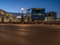 the city skyline is at night from the street level with traffic and pedestrians walking on it