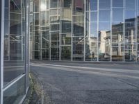 the old car is parked by the side of the building near the street in front of the glass wall