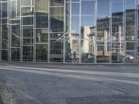 the old car is parked by the side of the building near the street in front of the glass wall