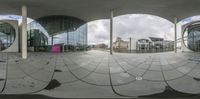 a fish eye lens picture of a view of a plaza of the city, including buildings