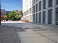 there is a view of a road and building with blurry background while on the left side is a view of the street is with a sidewalk