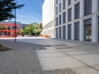 there is a view of a road and building with blurry background while on the left side is a view of the street is with a sidewalk