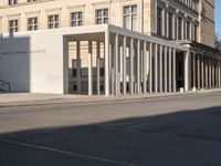 a photo taken outside of an old building with columns and pillars on the street side