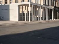 a photo taken outside of an old building with columns and pillars on the street side