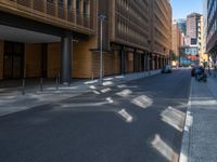 a road through which is a large modern building with an awning over it's entrance