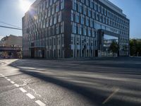 the sun shines over the windows and buildings near an empty street in a city