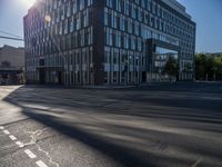 the sun shines over the windows and buildings near an empty street in a city