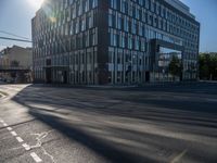 the sun shines over the windows and buildings near an empty street in a city