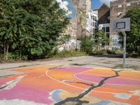 a basketball court in a rundown neighborhood surrounded by trees and graffiti on the walls