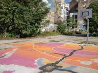 a basketball court in a rundown neighborhood surrounded by trees and graffiti on the walls