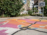 a basketball court in a rundown neighborhood surrounded by trees and graffiti on the walls