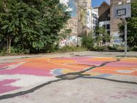 a basketball court in a rundown neighborhood surrounded by trees and graffiti on the walls