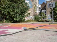 a basketball court in a rundown neighborhood surrounded by trees and graffiti on the walls