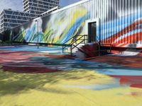 a multicolored painting on a steel container wall next to stairs and street lights