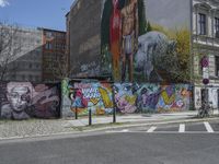 the street in front of the graffiti covered building is empty and empty, but has two rows