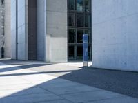 the man is sitting on his luggage in front of an empty building on the sidewalk