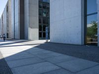 the man is sitting on his luggage in front of an empty building on the sidewalk