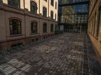 a sidewalk with chairs next to the brick building on the side, some have stairs and some buildings in the background