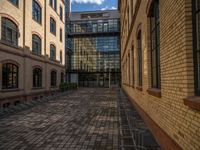 a sidewalk with chairs next to the brick building on the side, some have stairs and some buildings in the background