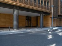 a road through which is a large modern building with an awning over it's entrance