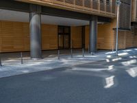 a road through which is a large modern building with an awning over it's entrance