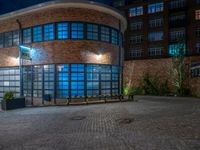 some dark blue windows in an industrial building with no one on the street to the right