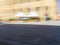 blurred picture of a person riding a bike near buildings in an old town square,