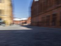 blurred picture of a person riding a bike near buildings in an old town square,