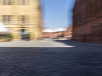 blurred picture of a person riding a bike near buildings in an old town square,