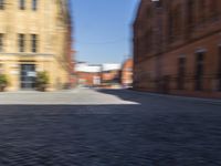 blurred picture of a person riding a bike near buildings in an old town square,