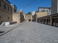 the sidewalk is paved with stones and has a bench in front of it, with no people inside