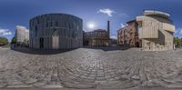 360 - spherical photograph of city street with buildings, and cobblestones at the end