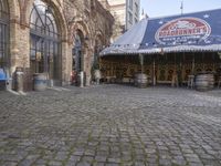 the old time store is selling various items for sale under an awning on cobblestone