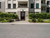 a view of the outside of a building with green shutters and landscaping on the side